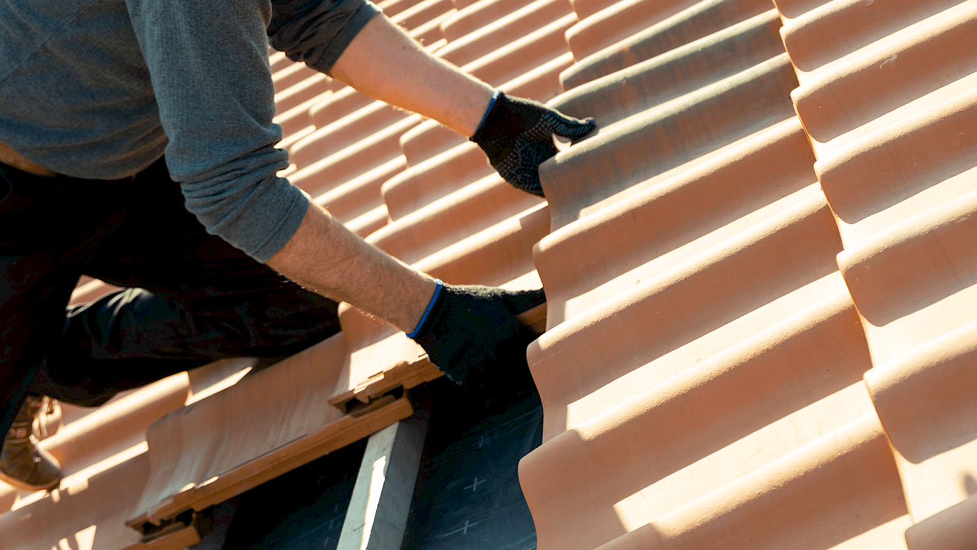 Roofing team fitting new roof tiles on house - request a quote