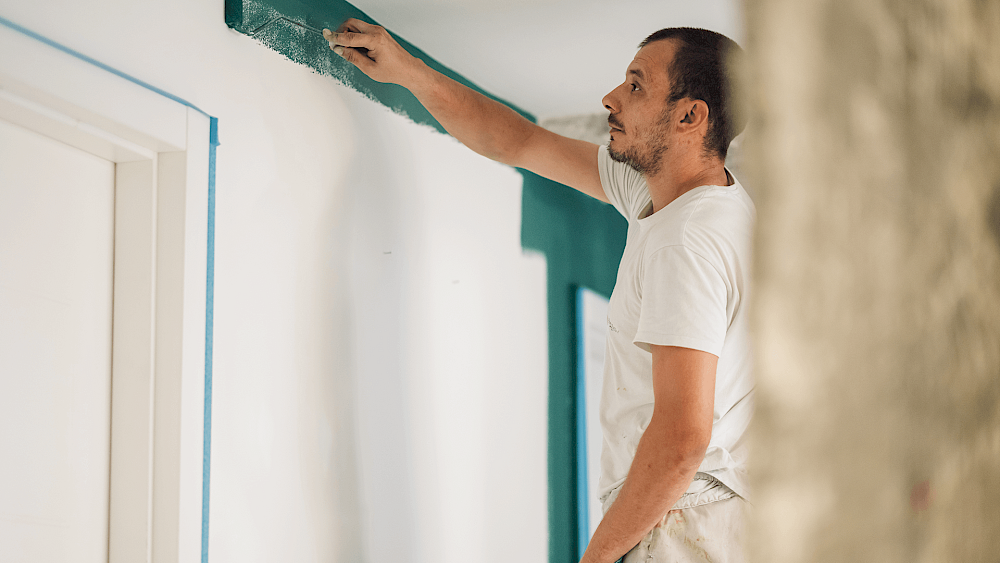 Painter decorating interior walls of home - request a quote