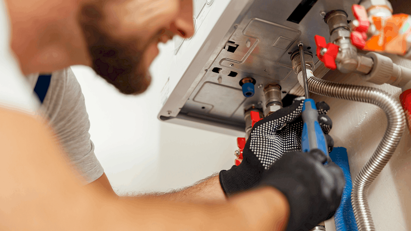 Heating engineer inspecting domestic gas boiler - request a quote